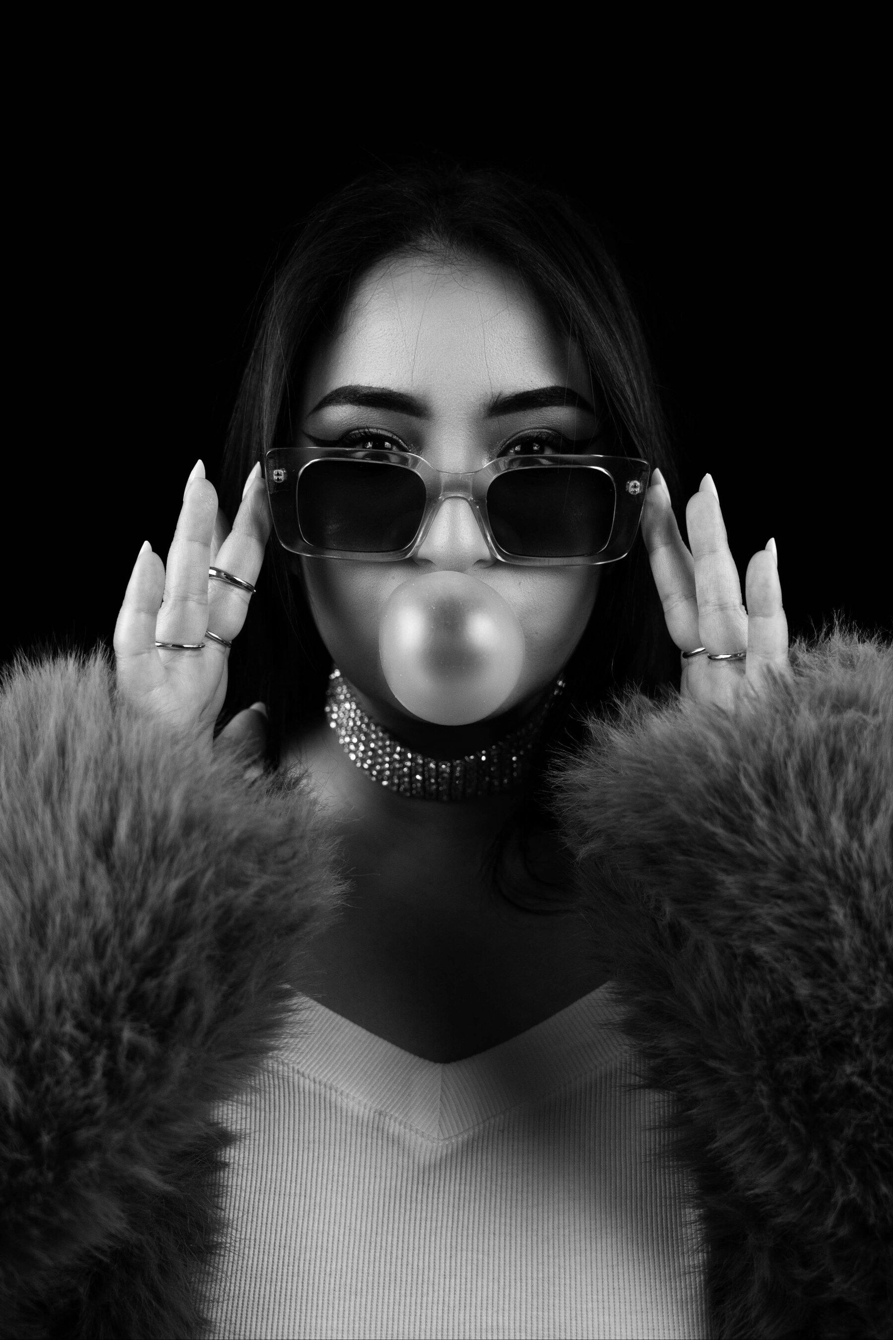 DJ Wided, lunettes de soleil et bulle de chewing-gum, portrait noir et blanc